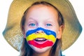 Laughing little girl in straw hat with painted face having fun