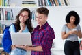 Laughing male student with nerdy girl at computer