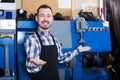 Laughing worker showing his workplace and tools