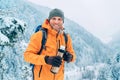 Laughing Man dressed bright orange softshell jacket with a hot drink thermos flask looking at camera while he trekking winter Royalty Free Stock Photo