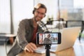 Laughing man podcaster shooting live video podcast on smartphone in studio Royalty Free Stock Photo