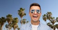 Laughing man in sunglasses over palm trees Royalty Free Stock Photo