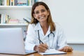 Laughing mature adult female doctor at work at office Royalty Free Stock Photo