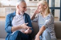 Laughing mature carefree spouses spend weekend leisure at home