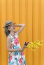 Laughing mature woman Flowers Straw hat Yellow background Royalty Free Stock Photo