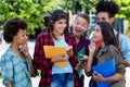 Laughing mexican female student learning with group of latin and african american young adults Royalty Free Stock Photo