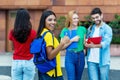 Laughing mexican female student showing thumb up with group of students Royalty Free Stock Photo