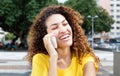 Laughing mexican girl at phone outdoor in city Royalty Free Stock Photo