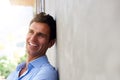 Laughing middle age man leaning against wall