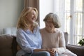 Laughing middle-aged woman enjoy talk with older mother