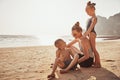 Laughing Mother and children sitting on a sandy beach Royalty Free Stock Photo