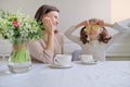 Laughing mother and daughter drinking from cups and eating lemon Royalty Free Stock Photo