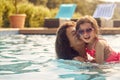 Laughing Mother And Daughter Wearing Sunglasses Having Fun In Swimming Pool On Summer Vacation Royalty Free Stock Photo