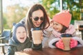 Laughing mother with two little kids having great time together in a sunny outdoors cafe Royalty Free Stock Photo