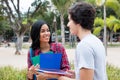 Laughing native latin american female student talking with caucasian friend