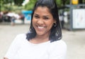 Laughing native latin woman in a white shirt in city