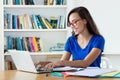 Laughing nerdy female student learning language online using computer