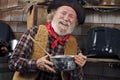 Laughing old cowboy cook holds a saucepan Royalty Free Stock Photo