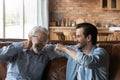 Laughing old father bumping fists with adult son