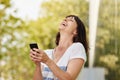 Laughing older woman holding smart phone outside