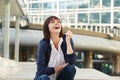 Laughing older woman sitting outside in city Royalty Free Stock Photo