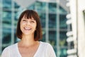 Laughing older woman standing outside in city