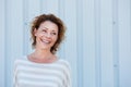 Laughing older woman standing by wall outside