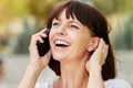Laughing older woman talking on smart phone outside Royalty Free Stock Photo