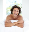 Laughing, portrait and a handsome man in bed for sleep, relaxing and rested in the morning. Wake up, resting and a guy Royalty Free Stock Photo