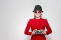 Laughing and Positive Caucasian Blond Girl With Old School Film Camera in Red Dress with Sunglasses. Taking Pictures Against White Royalty Free Stock Photo