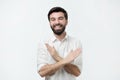 Laughing positive spanish guy dressed in white shirt showing stop gesture, asking to stop joking.