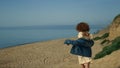 Laughing girl running down seashore with arms outstretched. Woman walking beach. Royalty Free Stock Photo