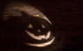 Laughing pumpkin Halloween Jack-o'-lantern of shadow on a dark wooden background. Jackolantern