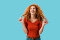 Laughing redhead girl isolated on blue