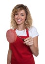 Laughing saleswoman with blond hair with italian salami