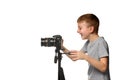 Laughing schoolboy shoots video on DSLR camera. Side view. White background, isolate