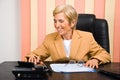 Laughing senior business woman using calculator