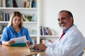 Laughing senior general practitioner with nurse Royalty Free Stock Photo