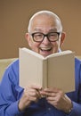 Laughing senior male reading a book