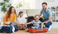 Playful kids in suitcases with parents on sofa behind Royalty Free Stock Photo