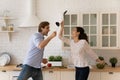 Laughing spouses having fun at kitchen fighting in crazy mood Royalty Free Stock Photo