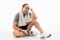 Laughing strong mature sportsman sitting with towel and water