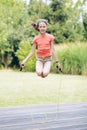 Laughing teenage girl jumping rop