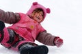 A laughing child sliding in the snow