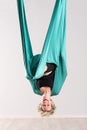Laughing upside down woman doing aerial yoga