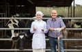 Laughing veterinarian chatting with farmer