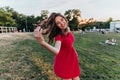 Laughing winsome woman with dark hair posing on nature background. Carefree female model in red dres Royalty Free Stock Photo