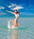 Laughing woman in bikini jumping in the sea on a sunny day Royalty Free Stock Photo