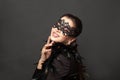Laughing woman in black carnival mask. Glamorous beauty fashion model on black background