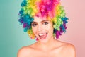 Laughing woman in colorful wig licking tongue lips. Funny woman face close up. Crazy girl studio portrait. Lips fun. Royalty Free Stock Photo